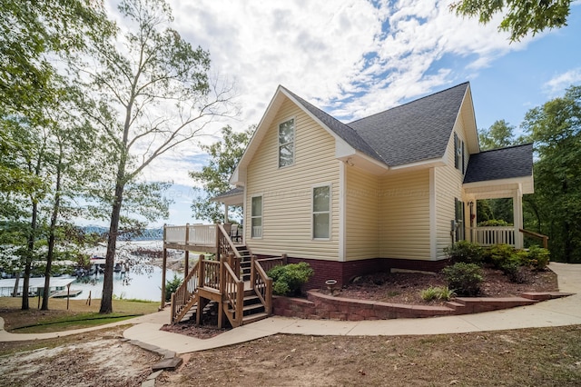 view of home's exterior featuring a deck with water view