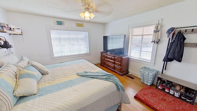 bedroom with multiple windows, ceiling fan, and light hardwood / wood-style flooring