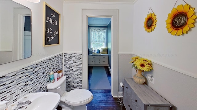 bathroom featuring sink, crown molding, toilet, tile walls, and wood-type flooring