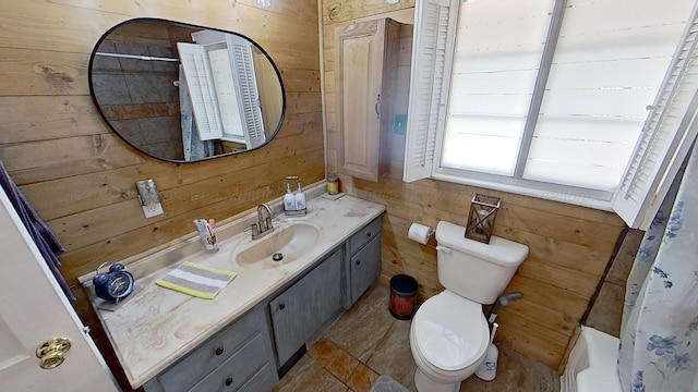 bathroom with walk in shower, wood walls, vanity, and toilet