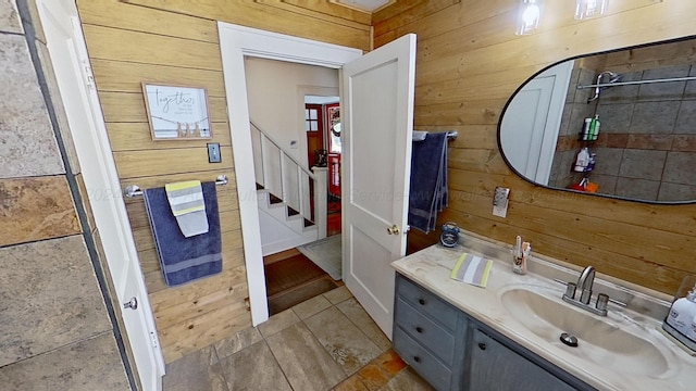 bathroom with vanity and wood walls