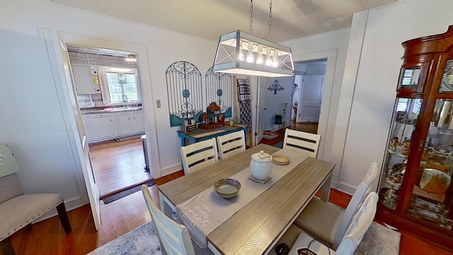 dining space featuring hardwood / wood-style floors, a notable chandelier, and sink