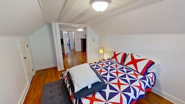 bedroom with hardwood / wood-style floors and lofted ceiling