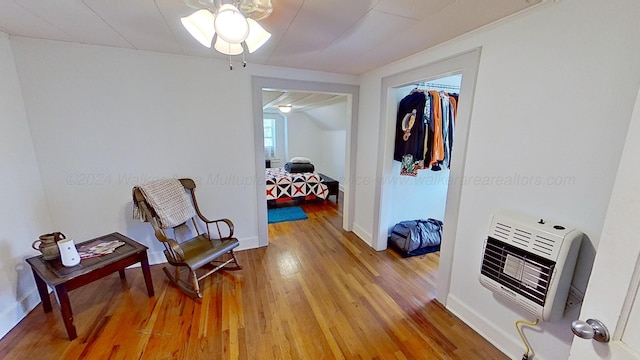 hallway featuring hardwood / wood-style floors, vaulted ceiling, and heating unit