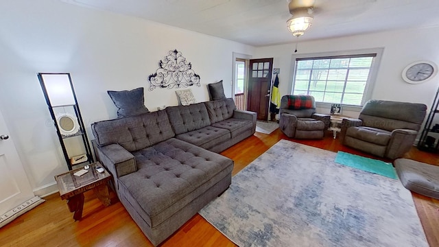 living room with ceiling fan, a baseboard radiator, and wood-type flooring