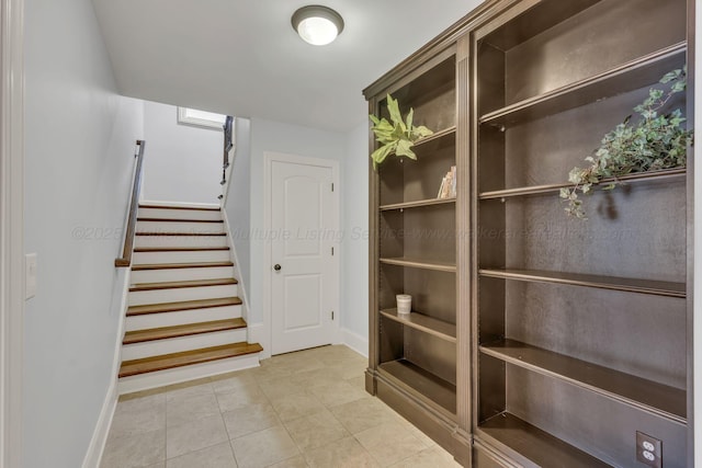 interior space featuring baseboards, stairway, and tile patterned floors