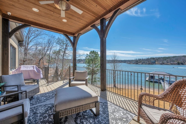 balcony featuring grilling area, a water view, and a ceiling fan