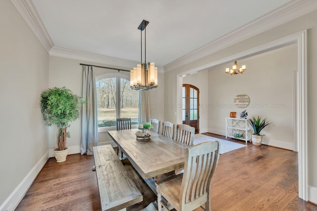 dining room with a chandelier, arched walkways, ornamental molding, and wood finished floors