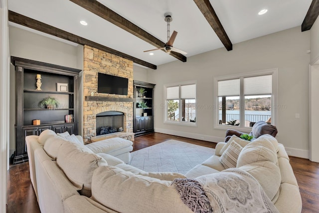 living room featuring beam ceiling, dark wood-style flooring, recessed lighting, a stone fireplace, and baseboards