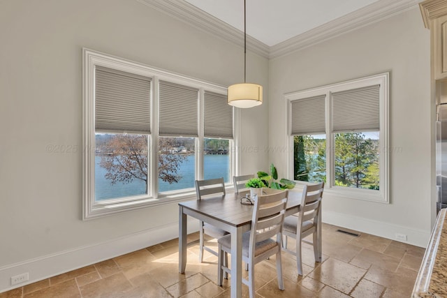 dining area featuring crown molding, stone tile floors, visible vents, a water view, and baseboards