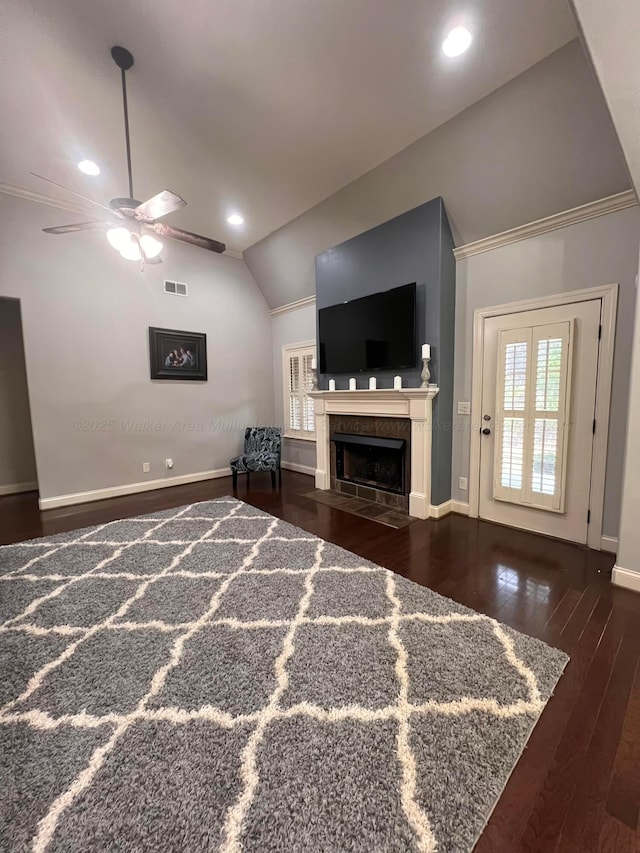 living room with ceiling fan, vaulted ceiling, a fireplace, and dark hardwood / wood-style floors