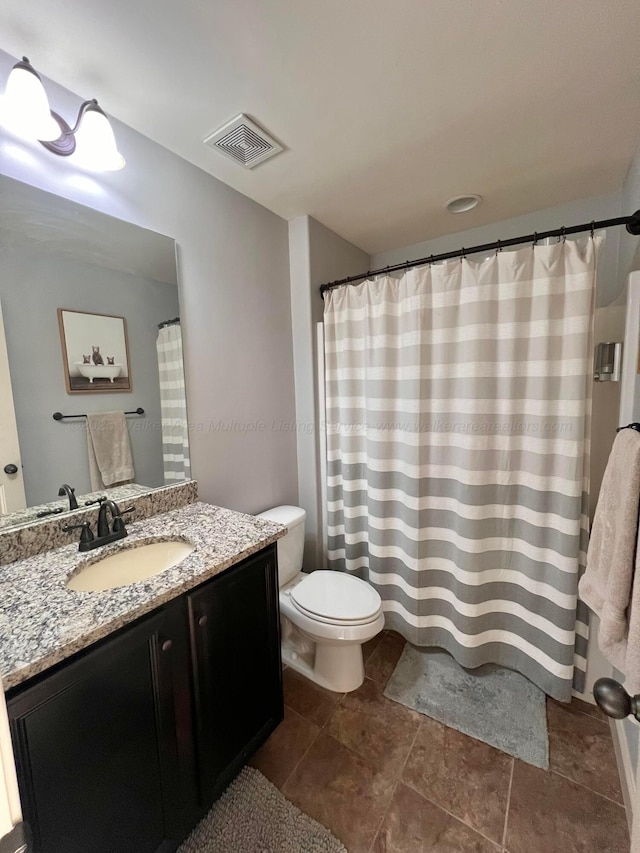 bathroom featuring toilet and vanity