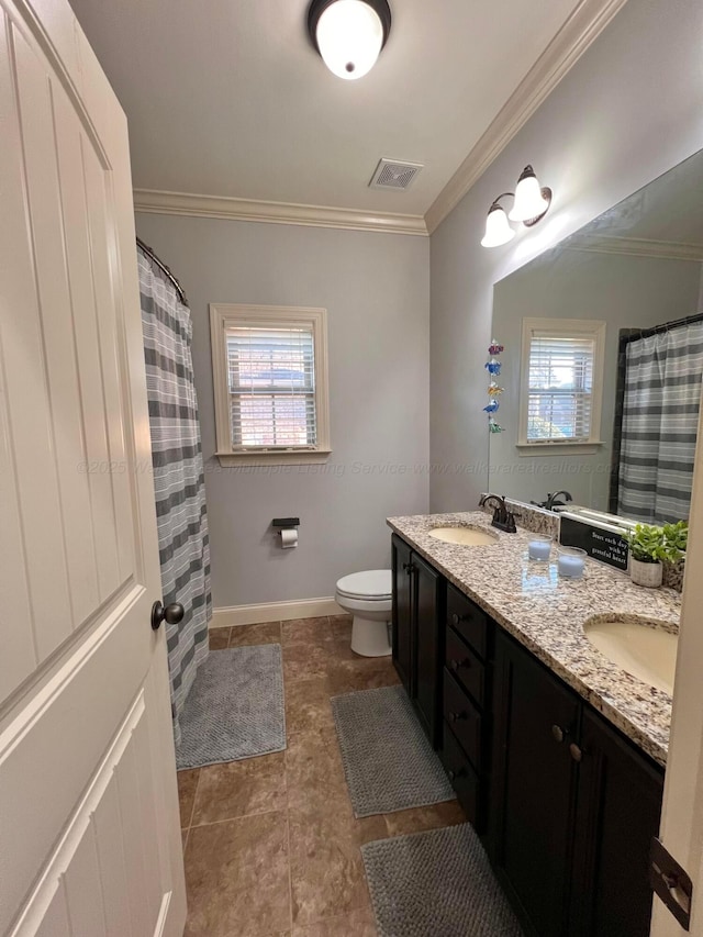 bathroom with toilet, ornamental molding, and plenty of natural light