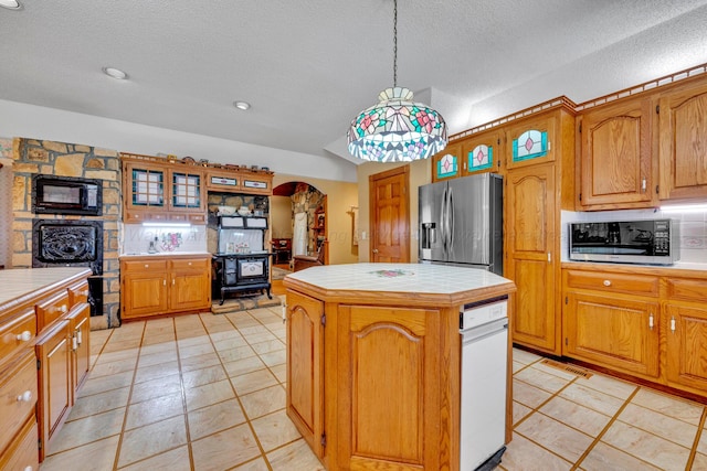 kitchen with a kitchen island, appliances with stainless steel finishes, tile countertops, backsplash, and hanging light fixtures