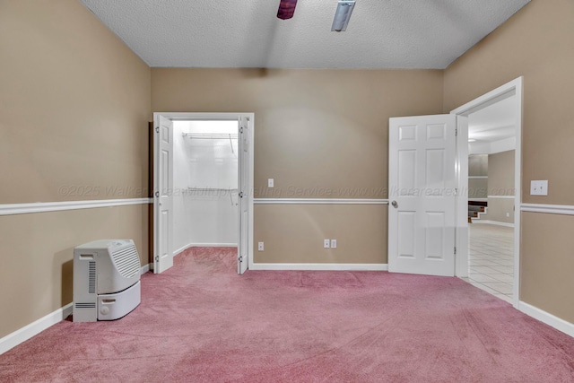 spare room with light carpet, ceiling fan, and a textured ceiling