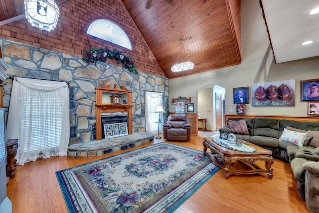 living room featuring hardwood / wood-style flooring, high vaulted ceiling, wood ceiling, and a fireplace