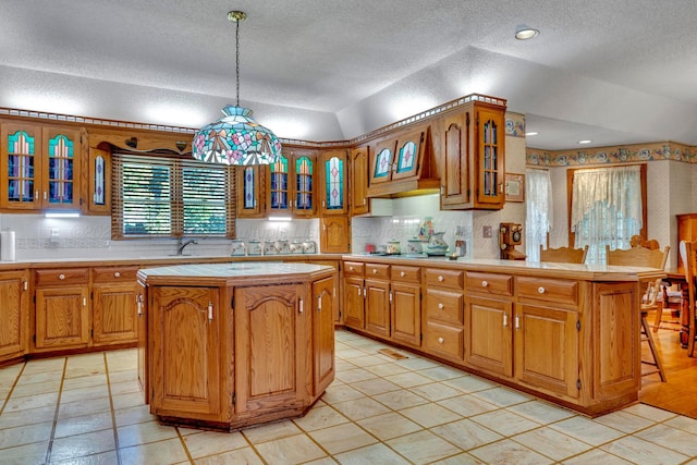 kitchen with pendant lighting, a kitchen breakfast bar, a kitchen island, and backsplash