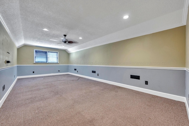 cinema room with vaulted ceiling, carpet flooring, ceiling fan, and a textured ceiling