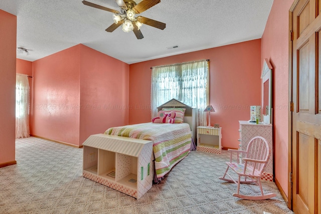 carpeted bedroom with ceiling fan and a textured ceiling