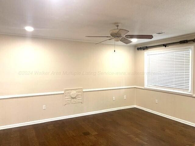 spare room featuring crown molding, ceiling fan, and dark wood-type flooring