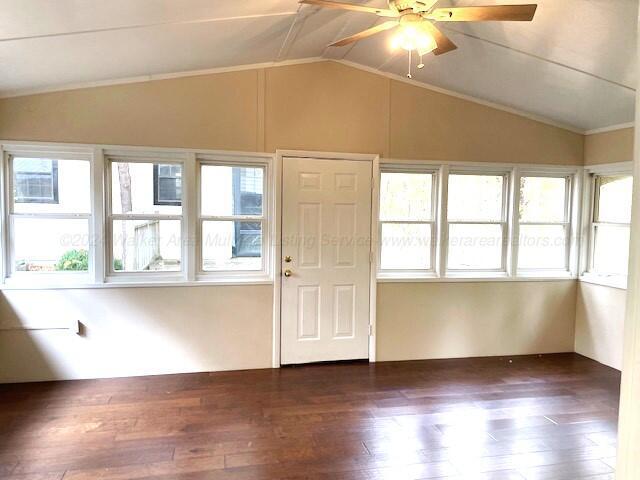 unfurnished sunroom with vaulted ceiling, ceiling fan, and a healthy amount of sunlight