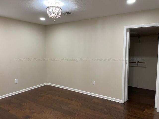 unfurnished room with dark hardwood / wood-style floors and a chandelier