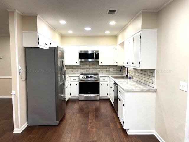 kitchen featuring white cabinetry, sink, stainless steel appliances, dark hardwood / wood-style floors, and crown molding