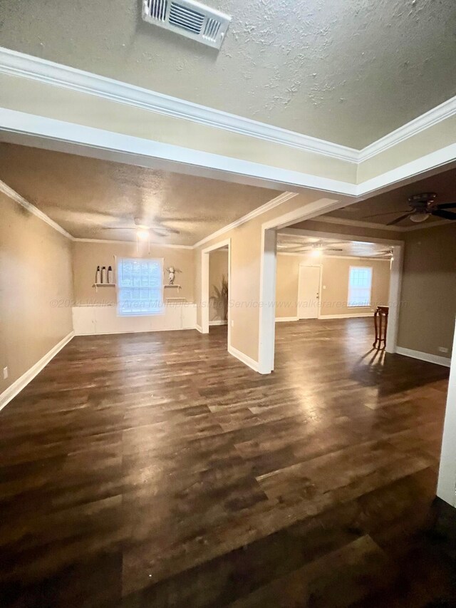 basement featuring ceiling fan, dark hardwood / wood-style flooring, ornamental molding, and a textured ceiling