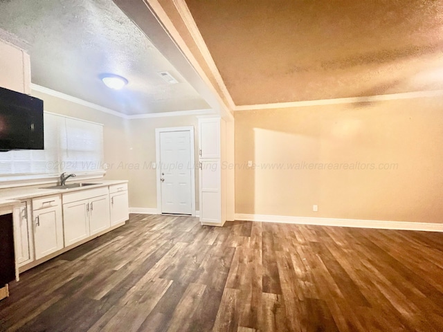 kitchen with white cabinetry, sink, crown molding, hardwood / wood-style floors, and a textured ceiling