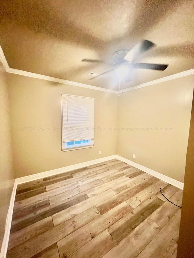 unfurnished room with crown molding, a textured ceiling, and hardwood / wood-style flooring