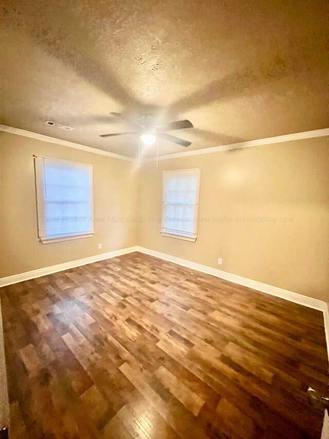 spare room with wood-type flooring, a textured ceiling, ceiling fan, and ornamental molding