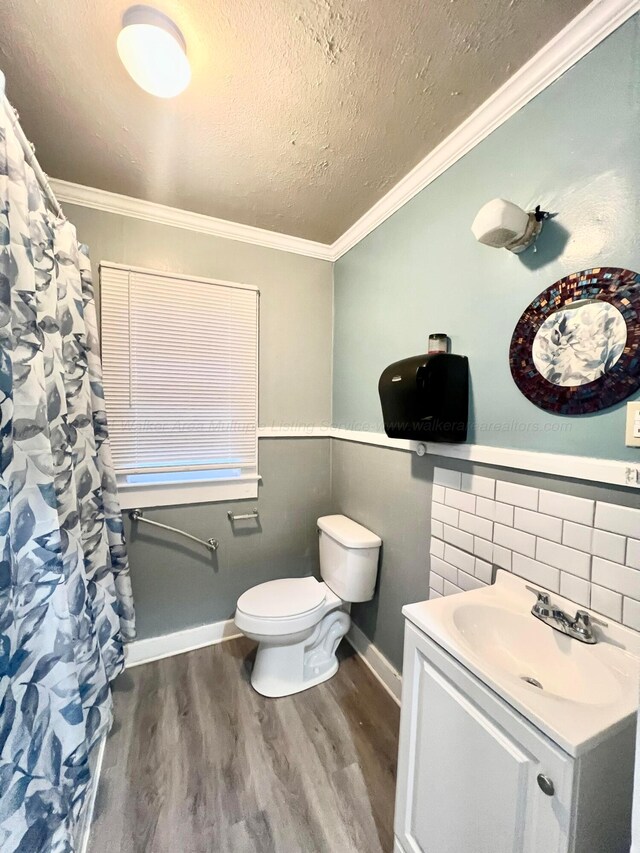 bathroom featuring wood-type flooring, vanity, toilet, and ornamental molding