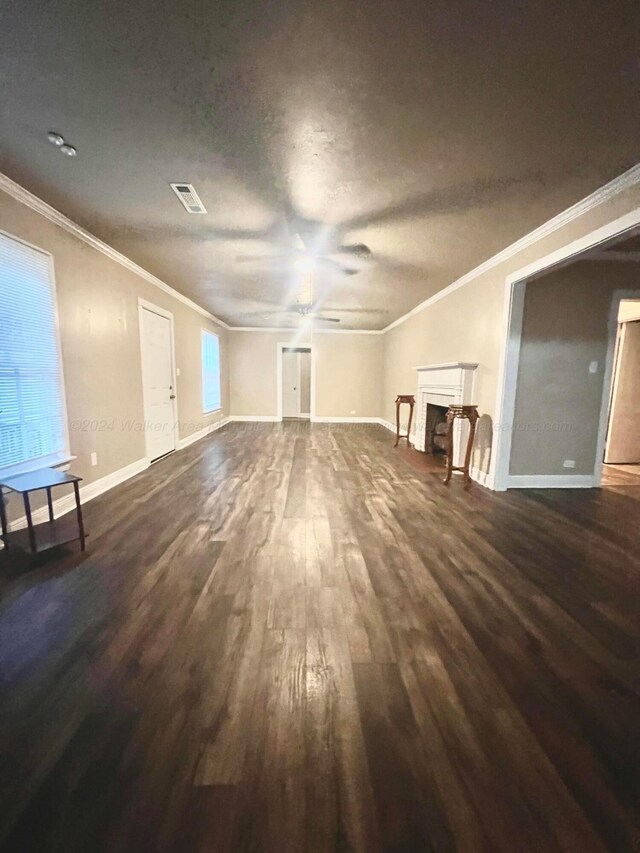 unfurnished living room with dark hardwood / wood-style floors, ceiling fan, and crown molding