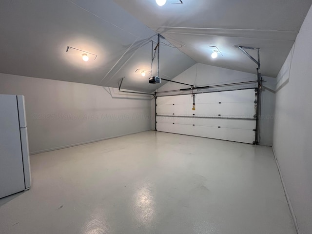 garage with a garage door opener and white refrigerator