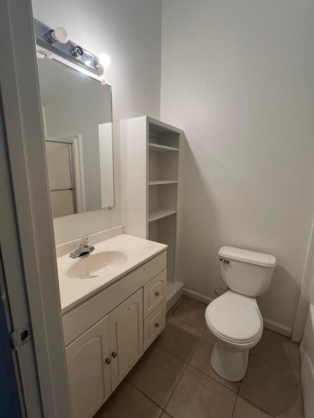 bathroom featuring vanity, a shower, tile patterned floors, and toilet