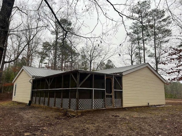 rear view of property featuring a sunroom