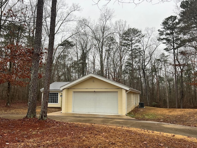 exterior space with central AC unit and a garage