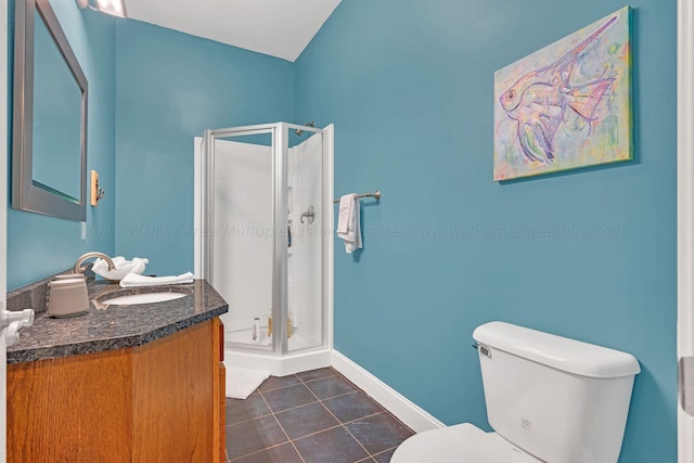 bathroom featuring tile patterned floors, vanity, toilet, and a shower with door