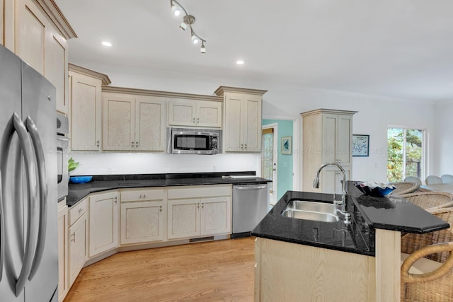 kitchen with sink, a breakfast bar area, a center island with sink, appliances with stainless steel finishes, and light wood-type flooring