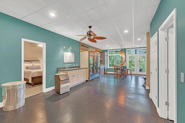 kitchen featuring ceiling fan, french doors, sink, decorative light fixtures, and a paneled ceiling