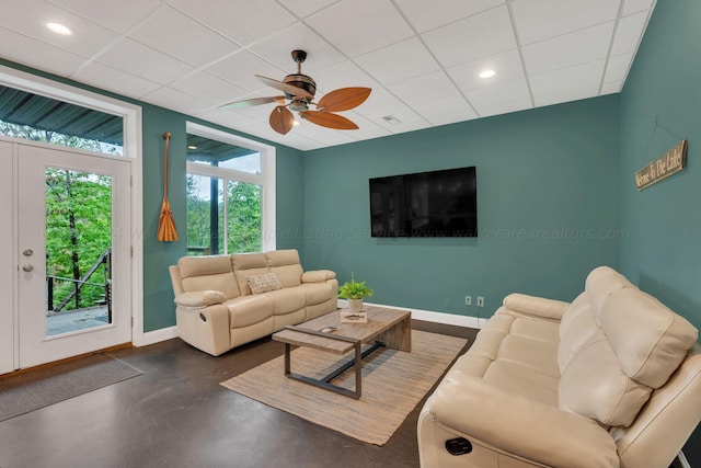 living room with ceiling fan and a drop ceiling