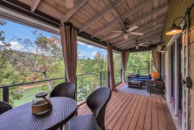 sunroom with lofted ceiling with beams, ceiling fan, and wood ceiling