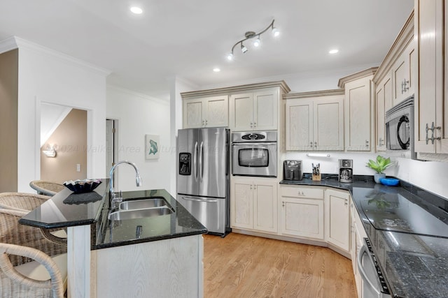 kitchen featuring sink, light hardwood / wood-style flooring, crown molding, a kitchen bar, and appliances with stainless steel finishes