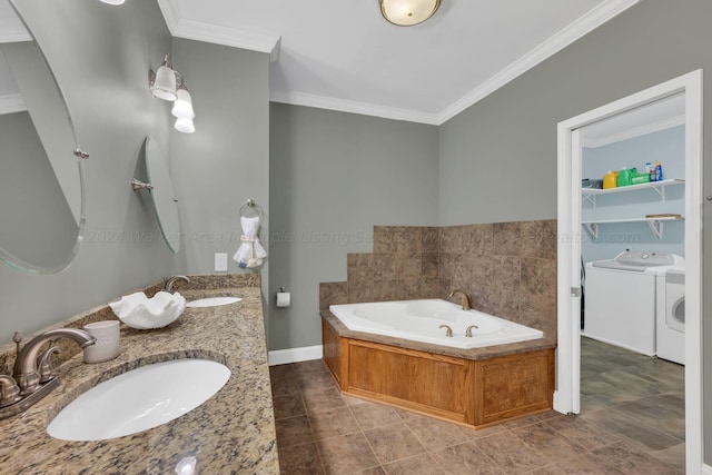 bathroom with a tub, tile patterned flooring, washer and clothes dryer, vanity, and ornamental molding