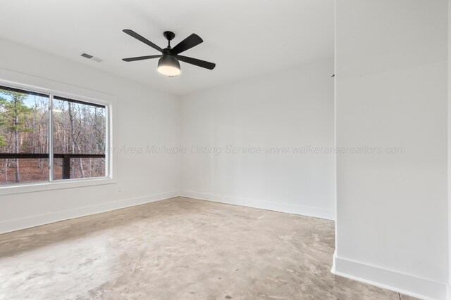 empty room with visible vents, ceiling fan, unfinished concrete floors, and baseboards