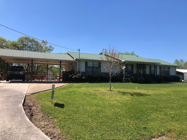 ranch-style home featuring a front lawn, metal roof, and a carport