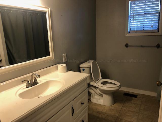 bathroom featuring toilet, baseboards, visible vents, tile patterned floors, and vanity