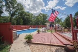 view of swimming pool featuring fence, a wooden deck, and a fenced in pool