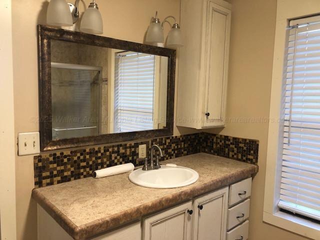 bathroom featuring vanity, tasteful backsplash, and a stall shower