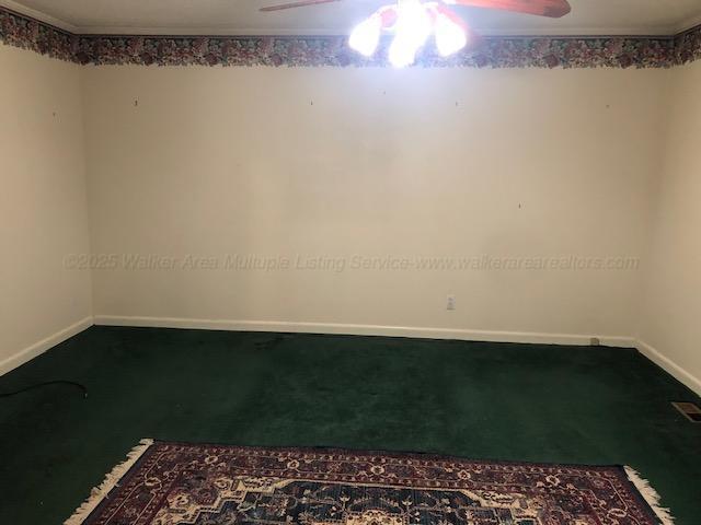 empty room featuring baseboards, ceiling fan, and carpet floors